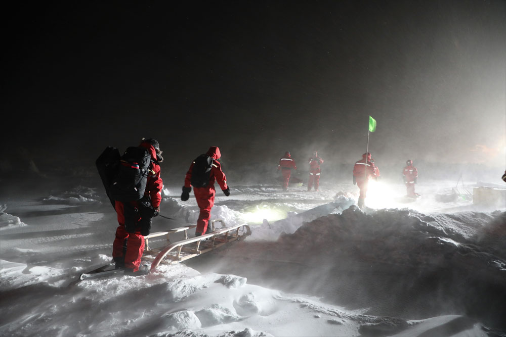 During the 2019–2020 Multidisciplinary Drifting Observatory for the Study of Arctic Climate (MOSAiC) expedition, team members use a sled as a footbridge to cross over a crack in the ice floe. The joint meeting featured early results from the expedition.