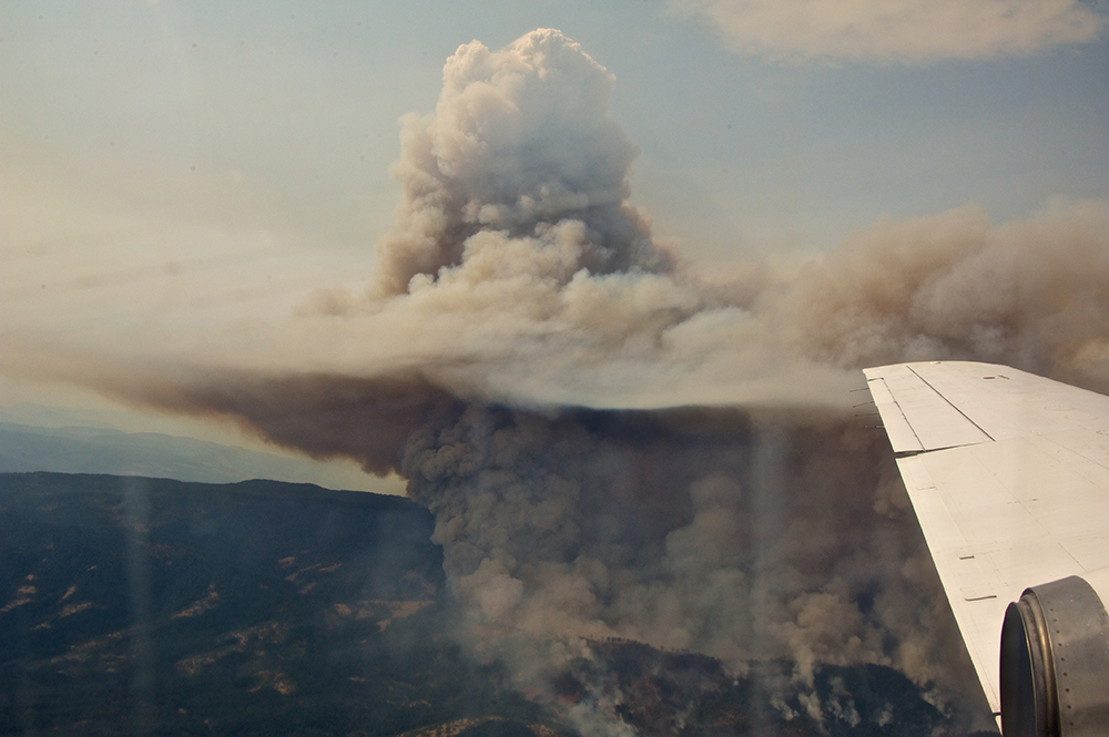 Seen from the G-1 aircraft, smoke from the Government Flat Complex wildfire spreads across the sky. 