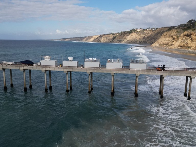 In November 2023, ARM instrument containers make a bold show on the Ellen Browning Memorial Pier in La Jolla, California. The instruments are collecting data for the Eastern Pacific Cloud Aerosol Precipitation Experiment (EPCAPE). Photo is by Gregory Roberts, Scripps Institution of Oceanography. 