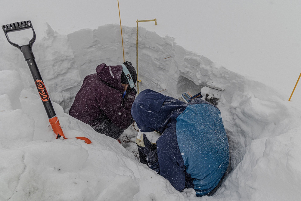 Schwat, right, and Hogan record measurements in a freshly dug snow pit.