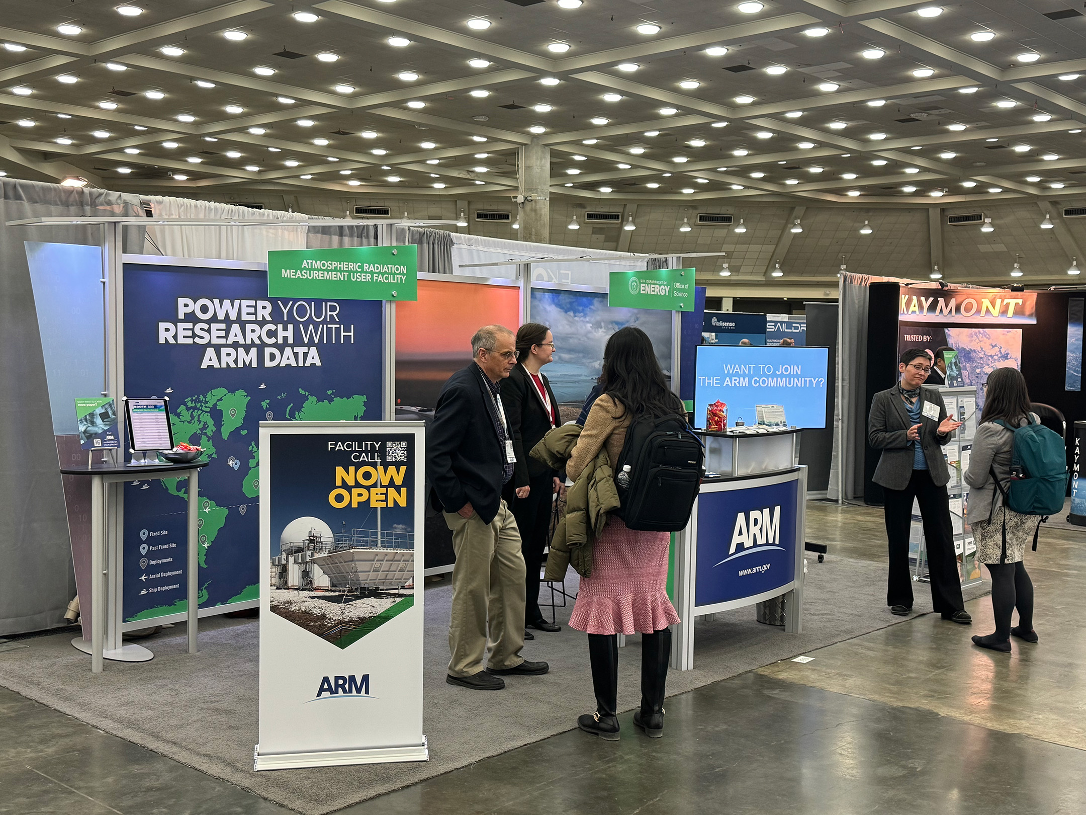 ARM and Atmospheric System Research (ASR) representatives chat with booth visitors during the 2024 American Meteorological Society Annual Meeting in Baltimore, Maryland.