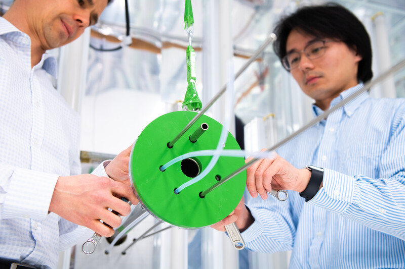 John Shilling and Earth scientist Yuzhi Chen adjust the gas inlet manifold on the environmental chamber. 