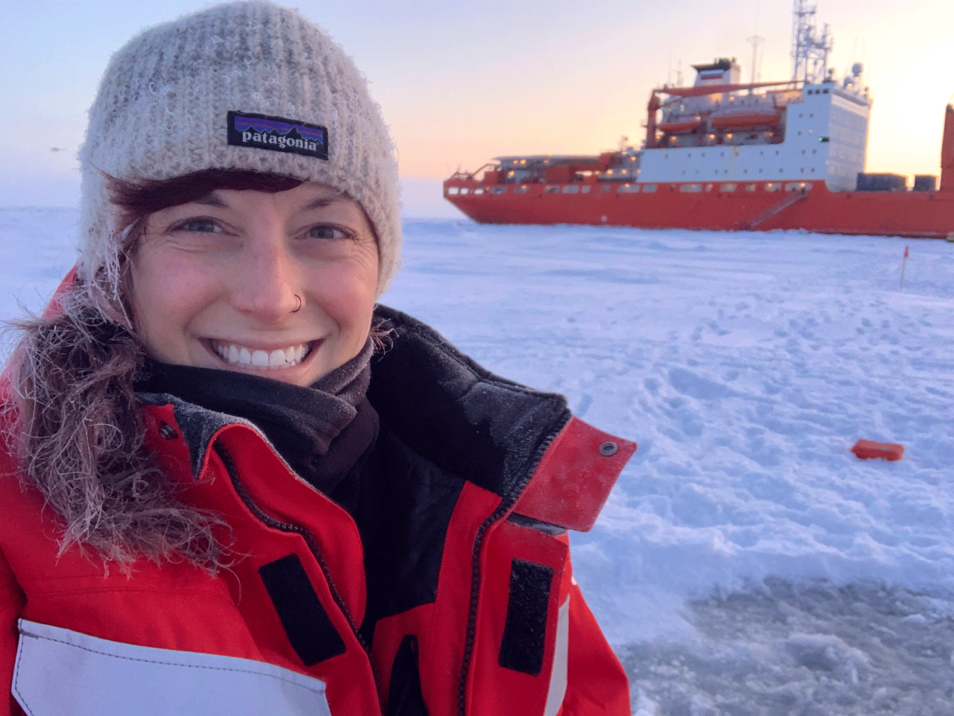 During MOSAiC, Jessie Creamean of Colorado State University measured aerosols with a portable device. Behind her is the Akademik Federov, a Russian vessel used to help install MOSAiC. 