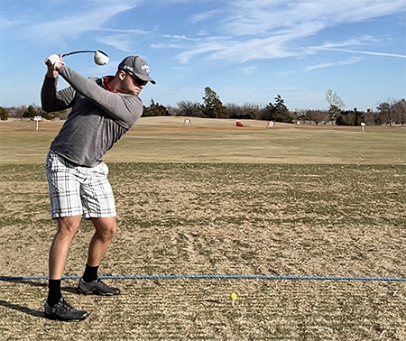 Aiming for the clouds at the Westwood Park driving range in Norman, Oklahoma, Dzambo winds up with during early-season golf practice in February 2023. 