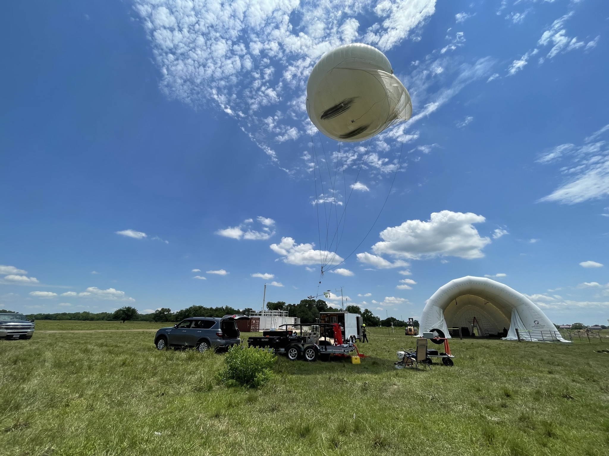 Under a blue sky in June 2022, an instrumented tethered balloon system eases aloft in Guy, Texas. Scientists are profiling atmospheric conditions along a vertical column 1.5 kilometers (0.9 miles) high. Photo is courtesy of Rolanda Jundt, Pacific Northwest National Laboratory. 