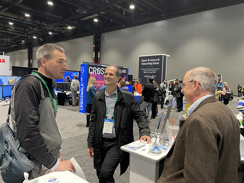 ARM users Gijs de Boer, left, and Pavlos Kollias, center, talk with ARM Director Jim Mather in the ARM exhibit at AGU 2022.