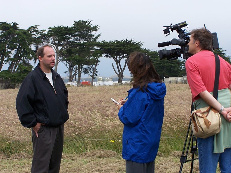 In 2005, Mark Miller paused for a media briefing during the Marine Stratus, Radiation, Aerosol, and Drizzle (MASRAD) field campaign in Northern California. He was also a site scientist for the first ARM Mobile Facility ever deployed. It is visible in the background, within a half-mile of the Pacific Ocean.