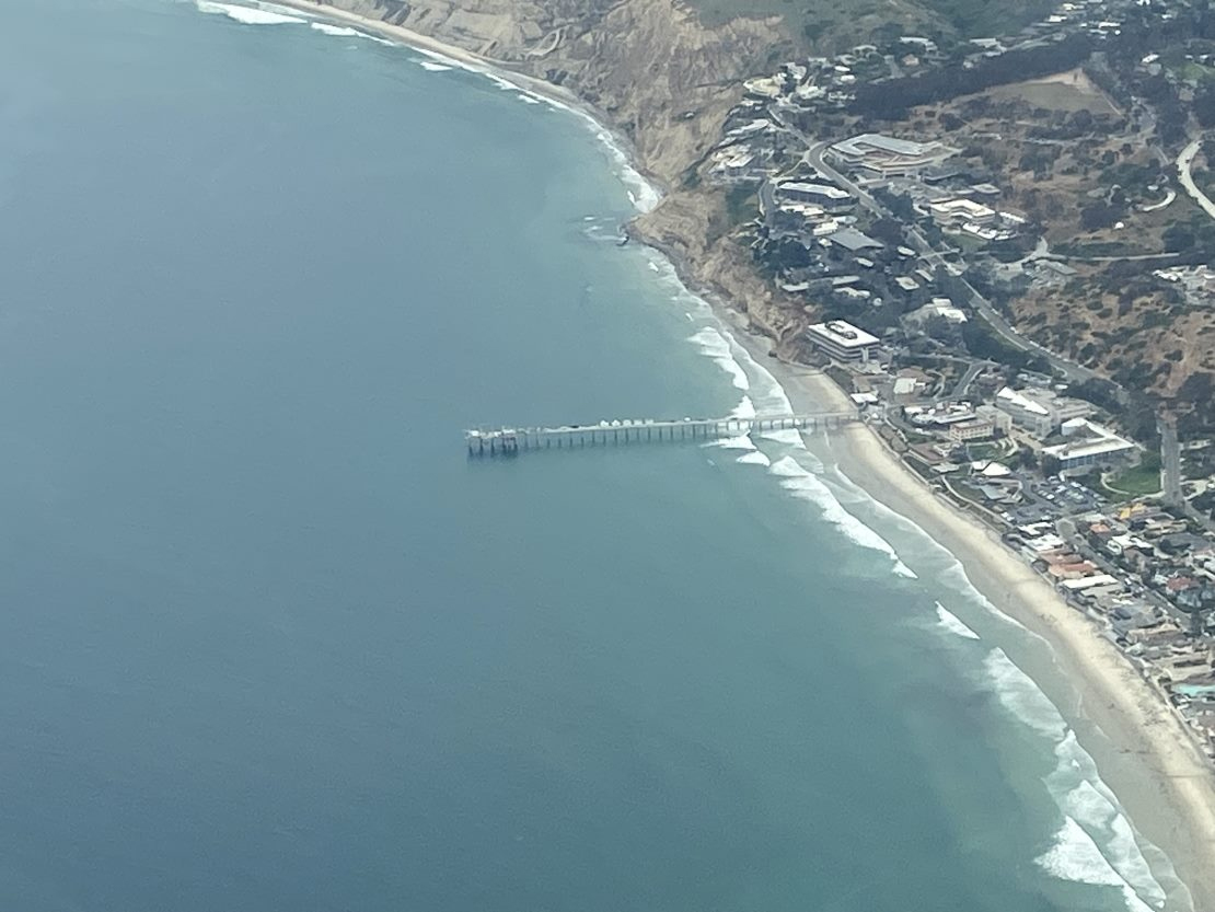 The Ellen Browning Scripps Memorial Pier, current home of the ARM Mobile Facility during the Eastern Pacific Cloud Aerosol Precipitation Experiment (EPCAPE), juts into the Pacific Ocean. This photo was taken June 6, 2023, from the Naval Postgraduate School’s Twin Otter research aircraft during a complementary four-week campaign called the Southern California Interactions of Low cloud and Land Aerosol (SCILLA) experiment. Photo is courtesy of Mikael Witte, Naval Postgraduate School.