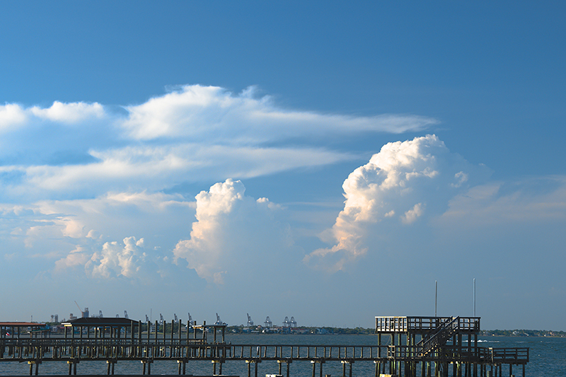 Sea-breeze influences were a big part of TRACER research on Houston-area factors affecting convective storms. Here, a line of decaying storms puffs in the sky near coastal Kemah, Texas, in June 2022. Photo is by Scott Collis, Argonne National Laboratory.