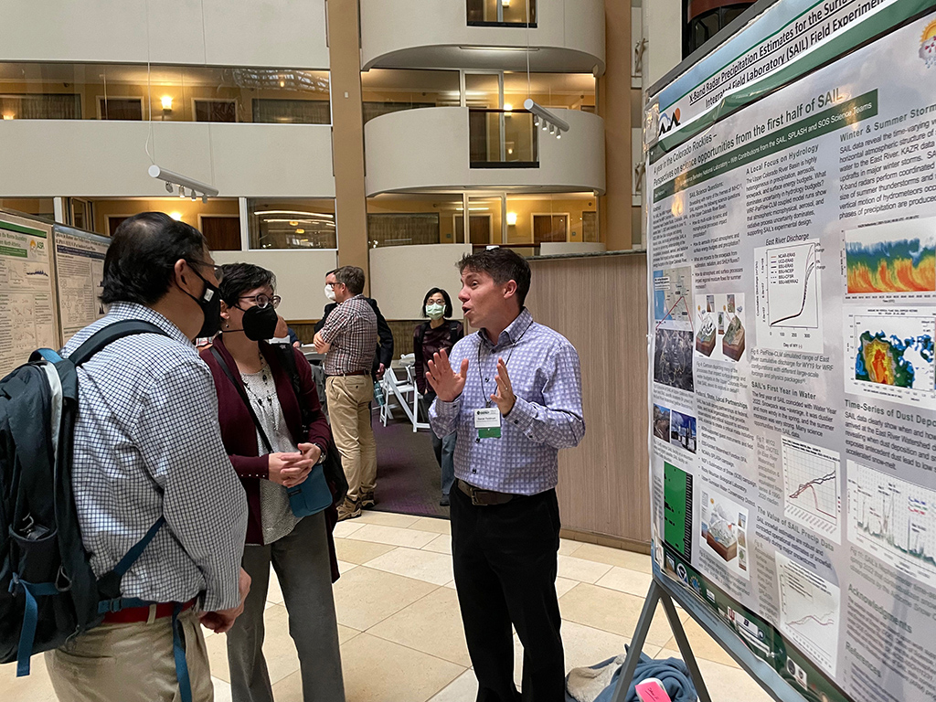 Daniel Feldman (right) discusses his poster on the Surface Atmosphere Integrated Field Laboratory (SAIL) campaign with DOE ASR Program Manager Shaima Nasiri (center) and Qiang Fu of the University of Washington. Feldman, a researcher at Lawrence Berkeley National Laboratory in California, is the lead scientist for the ongoing SAIL campaign in Colorado.